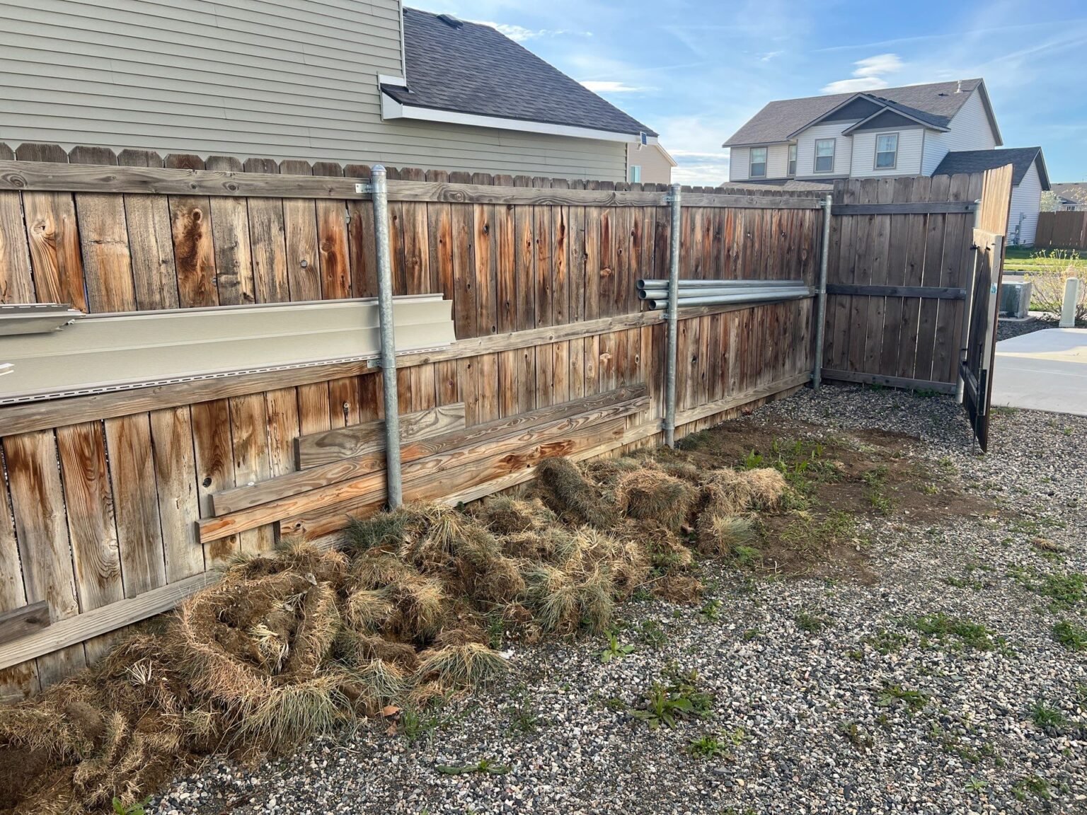 Grey, weathered cedar fence with sagging boards before restoration